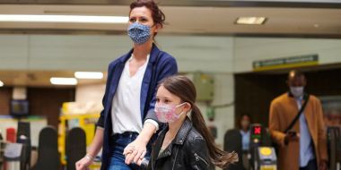 Mother & daughter wearing face masks in train station